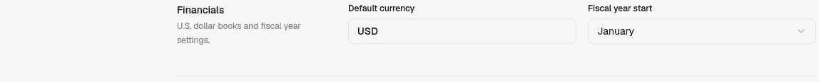 LedgerHQ Financials section showing USD default currency and the Fiscal year start month selector